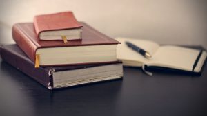 books, stories, writers, pile, stack, pages, paper, desk, pen